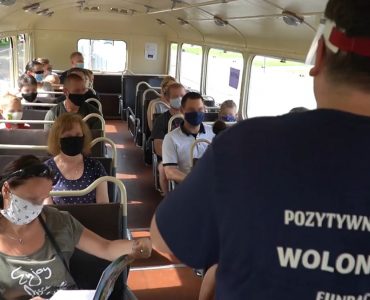zdjęcie obrazujące wnętrze autobusu Chausson z przewodnikiem oraz uczestnikami wycieczki