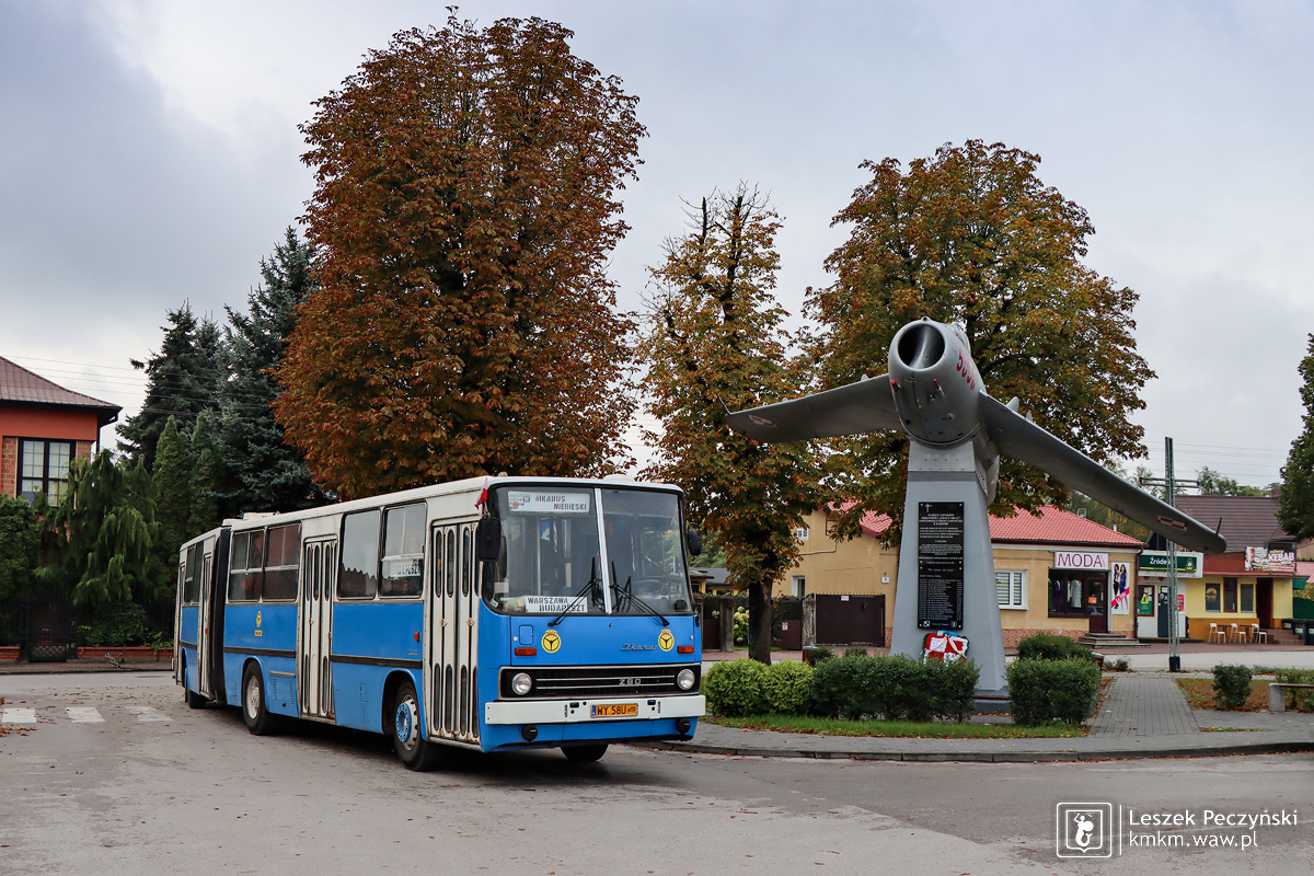 Niebieski Ikarus 280.02 obok pomnika samolotu w Nowym Mieście nad Pilicą