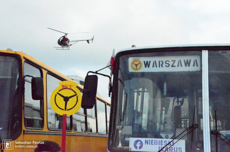 helikopter lecący nad wystawą autobusów