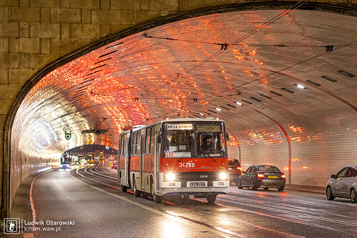 Krakowski autobus w tunelu Trasy W-Z, a za nim piękna gra białych i czerwonych świateł odbijających się w płytkach, którymi wyłożony jest tunel